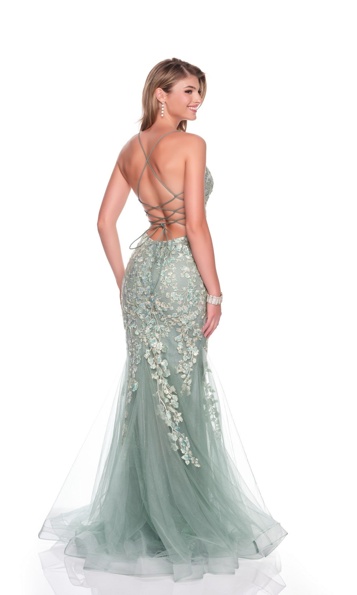 A woman poses against a white background wearing the Long Prom Dress: Dave and Johnny 12924, a mermaid-style light green gown with a lace-up open back and delicate embroidery appliques.